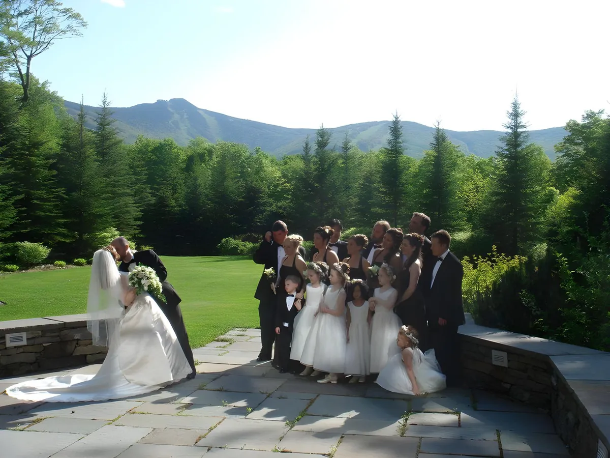 A lively group of people celebrating a wedding outdoors, set against a beautiful mountainous backdrop. The lush landscape and expansive views highlight the area's natural beauty and recreational potential beyond just ceremonies.
