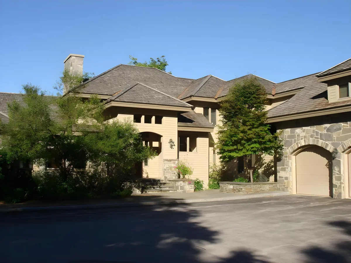 A welcoming front entrance framed by stonework and lush landscaping. The sunny porch is ideal for greeting guests or enjoying casual outdoor moments. The image conveys a sense of arrival and hospitality, suggesting a warm welcome for team members and executives alike.